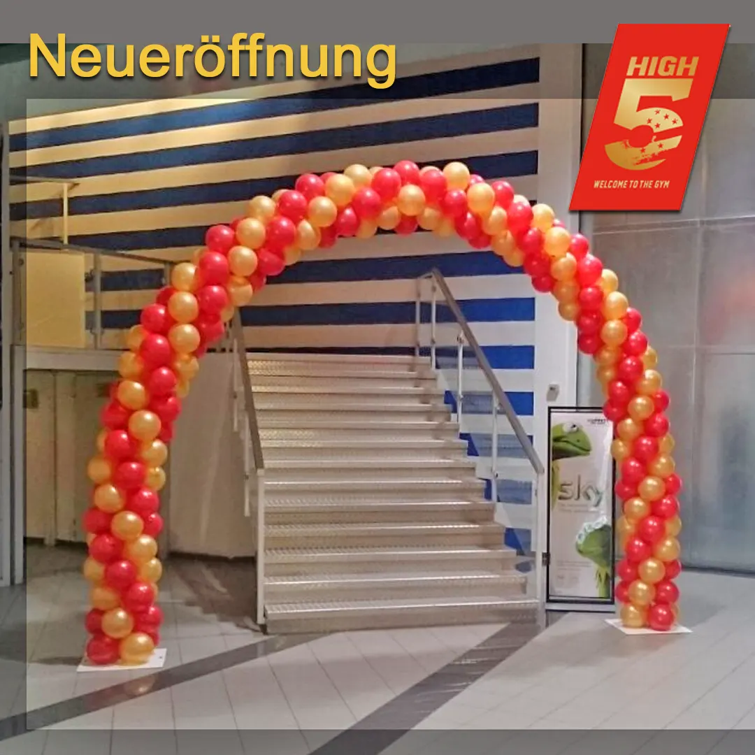 Ein traditioneller Ballonbogen in Rot und Gold schmückt den Eingang des neuen Fitnessstudios und strahlt Festlichkeit aus.