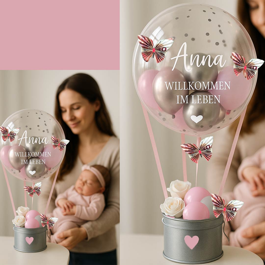 Das Foto zeigt ein liebevoll gestaltetes Ballongeschenk zur Geburt eines Mädchens mit dem Namen „Anna“. Der Fokus liegt auf dem transparenten Ballon mit rosa und silbernen Akzenten, gefüllt mit kleinen Luftballons, Konfetti und dekorativen Schmetterlinge