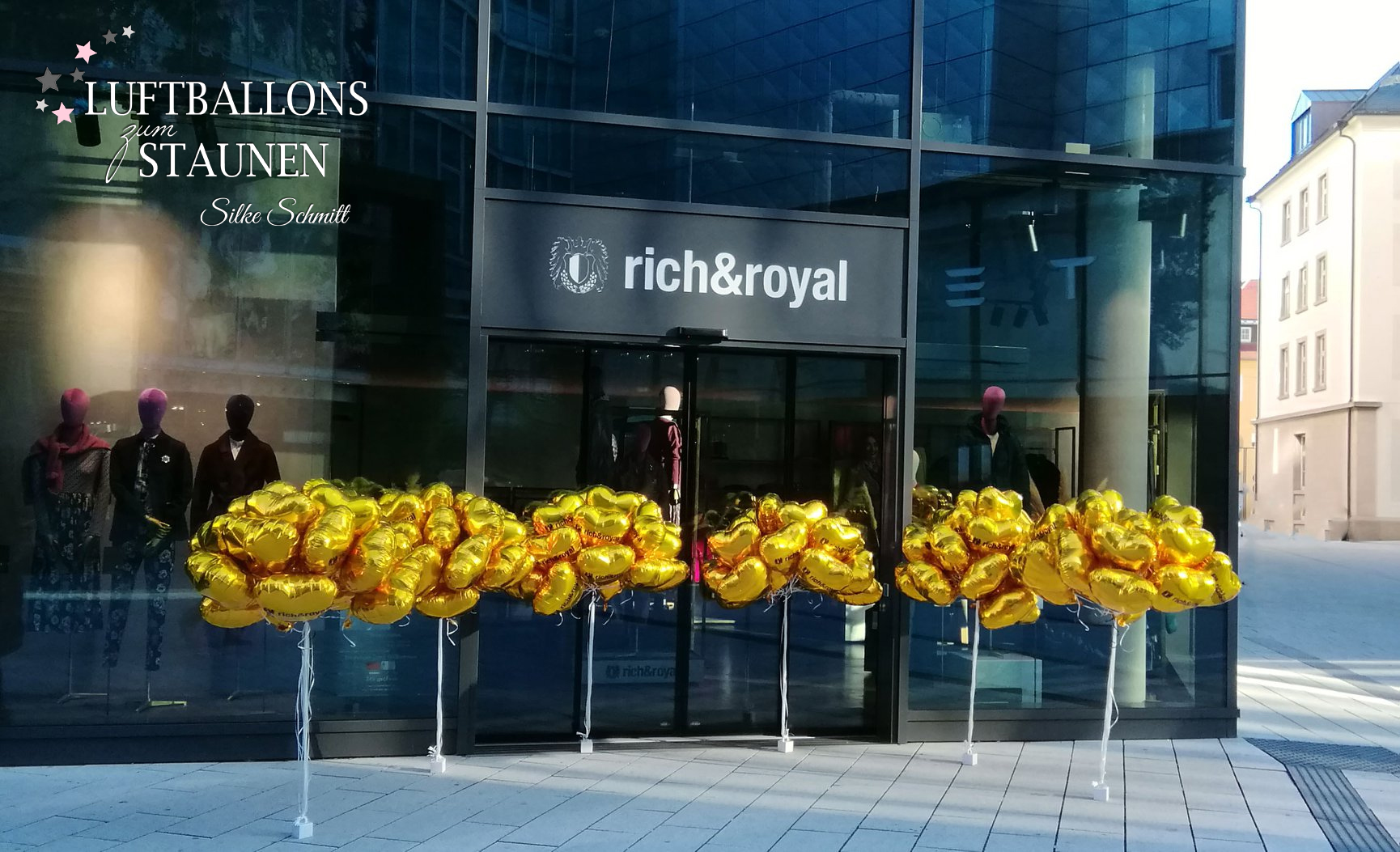 Filialeröffnung von Rich & Royal in Stuttgart. Die moderne Glasfassade des Stores wird von zahlreichen goldenen Folienballon-Herzen mit dem Logo des Unternehmens geschmückt.